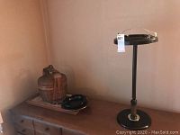 Woven basket with one metal ashtray and a decorative wooden container on a dresser