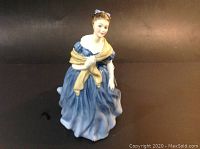 Front view of Royal Doulton Adrienne porcelain figurine showing detailed blue dress and yellow shawl