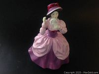 Front view of the Royal Doulton Lady Pamela figurine in pink and purple Victorian dress holding a mirror.