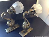 Pair of brass wall sconces with frosted glass globes and Edison switches showing full items