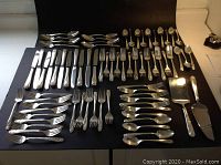 Full overhead view of all flatware pieces laid out on black background