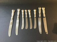 All eight knives arranged side by side showing dinner and butter knives.