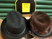 Three vintage men's hats with two original boxes visible behind them.