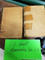 Front boards of both volumes laid side by side, showing worn cloth covers and tape reinforcements