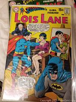 Photo showing Superman's Girl Friend Lois Lane #99 comic book with Batman and Superman on cover.