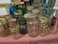 Full display of assorted glass mason jars and bottles showing various shapes, sizes, and lid types.