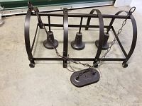 Side view of metal 3-light fixture showing rectangular metal frame, chain for ceiling suspension, and wiring.