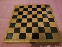Top view of square marble chess board showing alternating beige and black squares