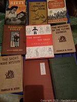 Top view of vintage books including Kitty Foyle, The Swallow Book, The Canterbury Tales, Ranson's Folly, The Home Toy Shop, The Mystery of the Flying Express, The Short-Wave Mystery, Collier's Travels, and Collier's Travels.