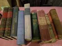 Two photographs showing a variety of vintage hardcover books arranged in two rows. The spines reveal classic literature, historical fiction, and specialty titles. Condition varies with noticeable wear and age marks.