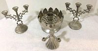 Image showing two ornate three-arm silver-toned candelabras and a lotus bowl candle holder with frog figure in the middle.