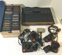 Overall view of console, controllers, paddles, RF adapter, power supply and game cartridges