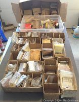 Overview of capacitors sorted in cardboard boxes with bagged components and envelopes