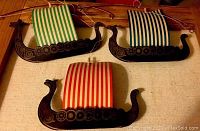Three vintage Viking ships mobiles showing striped sails in green, red, and blue colors.