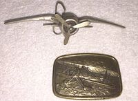 Metal 3D propeller buckle with central propeller blades, shaped to represent Vought F4U Corsair fighter plane propeller