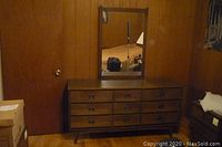 Full view of wooden dresser with mirror attached, showing six drawers and overall condition in room setting.