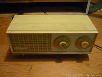Front angle view of vintage Zenith radio showing speaker grille and two control knobs on the right.