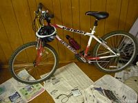 Side view of the Dunlop Patriot bicycle with dark blue helmet hanging on handlebars and visible red water bottle on frame.