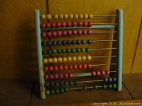 Front view of vintage wooden abacus showing colorful beads.