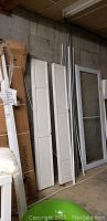 Photo showing the full group of bifold doors and the storm door frame leaning against a wall.