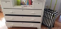 Photo showing the antique white bureau table with three drawers and two cubbies