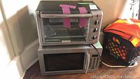 Black & Decker toaster oven on top of Silhouette microwave oven, corner placement.