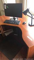 Full view of monitor, keyboard, mouse and lamp on desk