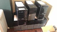 Eight black desktop towers in two rows: two HP Pavilion Elite HPE on top of six Dell OptiPlex 780