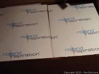 Top view showing four unopened boxes of Rolland Inspiration laser paper, each with visible packaging logos.