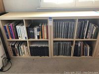 Two Ikea Expedit style shelves filled with assorted books and magazines, front view