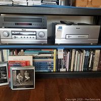 Shelf overview showing Yamaha CD changer (top left) and Sherwood AV tuner preamplifier (middle left) among books.