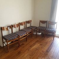 Front view of all six wooden dining chairs arranged in a row