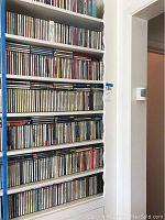 Photo of seven shelves filled with numerous classical music CDs showing variety in titles and colors.