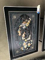 Top view of the table showing intricate mother of pearl floral and bird inlay design on black lacquer surface.