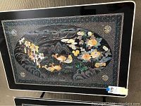 Top view of the Korean folding low table showing the full rectangular black lacquered surface with detailed mother of pearl inlay artwork featuring fish, birds, flowers, and traditional patterns.