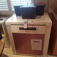 Fridge exterior closed with three plastic containers on top