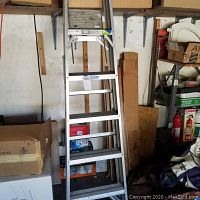 Image of the aluminum Werner ladder in storage, showing its height, rungs, and foldable structure.