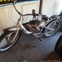 Full side view of white Areva bicycle with helmet on frame, showing overall condition and design.