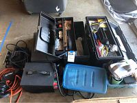 Full lot view including boxes, power transformer, charger, and tools