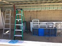 Wide angle photo showing both ladders side by side with plastic crates arranged nearby.
