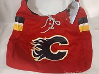 Front view of red Calgary Flames themed shoulder bag with flaming C logo and lace-up detail
