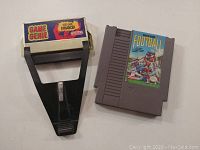 Front view of Nintendo Game Genie and NES Football game cartridge showing labels and general condition.