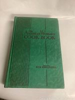 Front cover of the cookbook showing title and editor name with green textured cover and black lines.