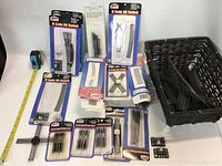 Lot of various N scale track components from Atlas brand including switches, track sections, and connectors shown arranged with measuring tape for scale.