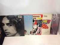 Front view showing five LP record album covers standing upright, from left to right: Bob Dylan Hard Rain, 13, Horror Show, For Un, and a purple cover album with red text and a symbol.