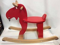 Side view of solid wood red rocking moose toy showing overall shape, wooden antlers, and rocker base.