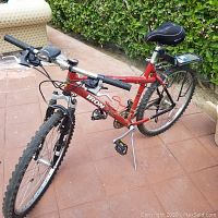 Overall view of red Iron Horse bike showing frame, wheels, handlebars, saddle, rack and kickstand