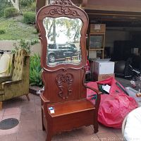 Full front view of vintage wooden hall entry bench with attached mirror and storage seat, showing carved wood details and overall structure.