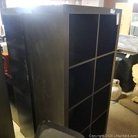 Two black shelving units with multiple open shelves arranged side by side