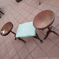Overview of two round wooden tables and small upholstered bench, showing condition and design